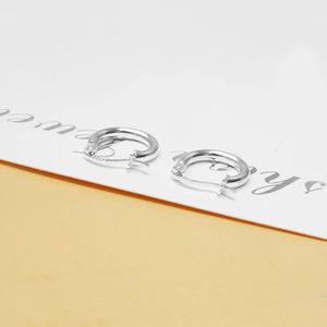 Macro view of minimalist S925 sterling silver hoop earrings with clear hallmark engraving