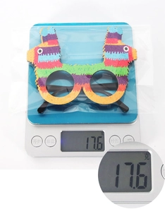 Detailed view of colorful alpaca party glasses on a scale showing 17.6g weight