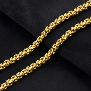 Vista macro detallada de un collar de cadena de dragón trenzado dorado con eslabones finos