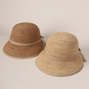 Close-up of elegant raffia straw sun hats with ribbon bow and split back details