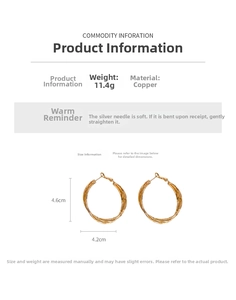 Detailed view of large golden hoop earrings with twisted texture and dimensions