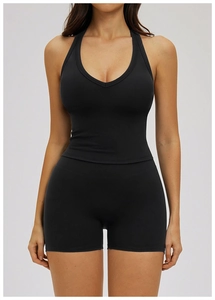 Front view of black halter neck sports bra and high-waisted shorts set on female model