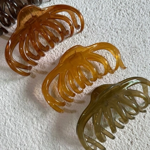 Close-up of translucent jelly hair claws in dark brown, amber, and forest green