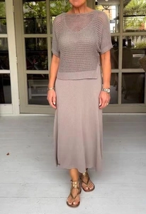 Dettaglio di un set a due pezzi in maglia taupe con top traforato e gonna lunga in maglia