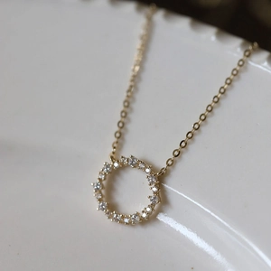 Detailed close-up of a 14k gold-plated S925 silver necklace with a zircon-encrusted circle pendant