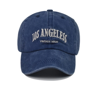 Close-up of white Los Angeles embroidery on a vintage navy blue washed cotton baseball cap