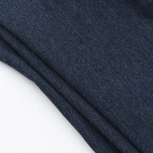 Detailed macro view of high-quality dark blue denim fabric with diagonal twill texture