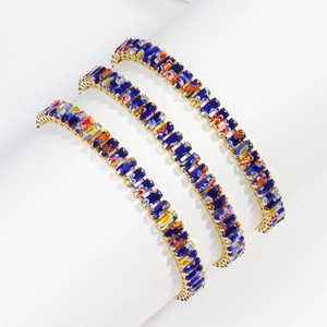 Detailed macro view of three rectangular blue and floral crystal bracelets on a white display