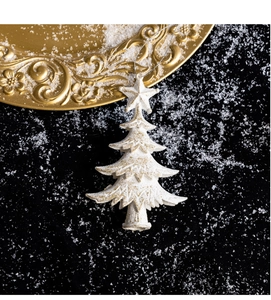 Detailed view of white and gold glitter Christmas tree ornament on snowy background