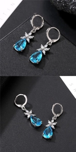 Detailed macro view of waterdrop blue zircon earrings with silver flower settings
