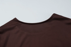 Détail du col rond de la robe en maille marron foncé avec texture tricotée fine