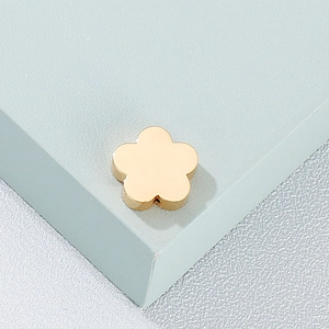 Collier avec pendentif fleur dorée minimaliste pour femme sur fond bleu clair texturé