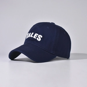 Close-up of white 3D TALES embroidery on navy cotton canvas baseball cap crown