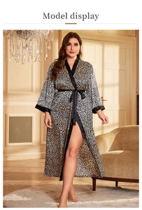 Detail of leopard print silk satin robe featuring black trimmed neckline and waist tie