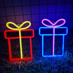 Close-up of gift box neon signs with bows glowing in red, yellow, blue, and pink colors
