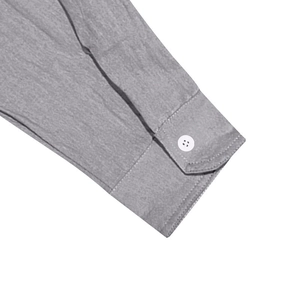 Detail of grey linen shirt cuff showing woven fabric texture and white button fastener