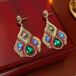 Gros plan de boucles d'oreilles vintage en or avec pierres précieuses et perles rouges