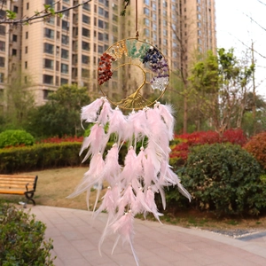 Detail of colorful crystal tree of life dreamcatcher with vibrant pink feathers