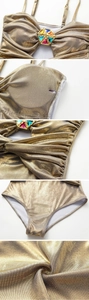 Close-up of golden metallic swimsuit with colorful gemstone stars and side lace-up details