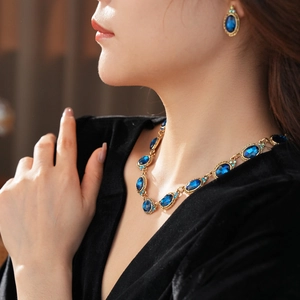 Gros plan d'une parure vintage avec collier et boucles d'oreilles aux pierres bleues
