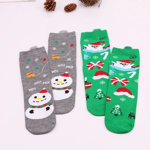 Detail of Christmas knit socks featuring Santa and Snowman patterns with festive pine cones