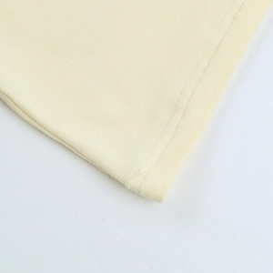 Gros plan détaillé de l'ourlet à double couture sur un haut en tricot de coton jaune clair