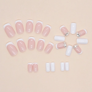 French tip press-on nails in creamy white with sparkling rhinestones and pearls