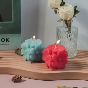 Detalle de velas florales 3D con textura de pétalos finos sobre una bandeja de madera