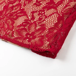 Close-up of red floral lace fabric with delicate mesh texture and beige lining details