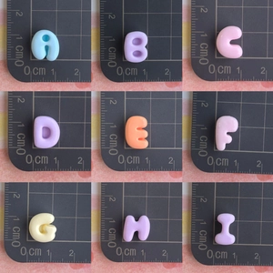 Vue détaillée de perles lettres en résine colorée de 1cm pour accessoires DIY
