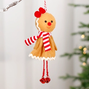 Cute gingerbread man doll pendant with red bow and bells on snowy Christmas tree branches