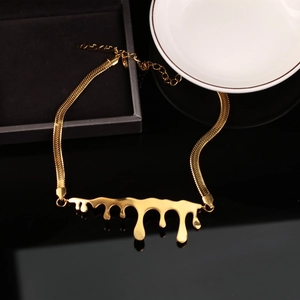Detail of gold fluid lava pendant with sleek snake chain on a premium black display
