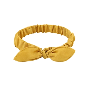 Detail of a bright yellow elastic bow headband with a soft satin texture and neat stitching