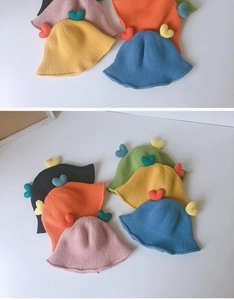 Close-up of knit fisherman hat for babies showing heart patch and texture in multiple colors