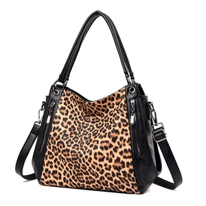 Large leopard print shoulder bag with black leather straps and zipper detail on white backdrop