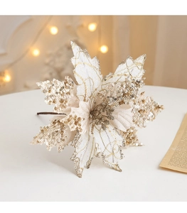 Macro shot of artificial cream Christmas flower with gold glitter petals on white table