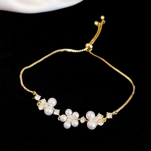 Macro view of a gold flower bracelet with pearls and sparkling cubic zirconia details