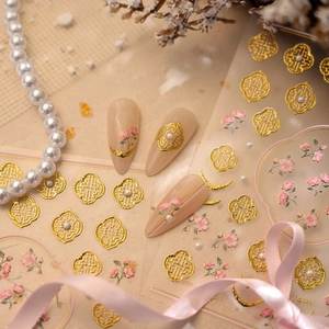 Golden Chinese window lattice nail stickers with pink floral designs and pearl accents