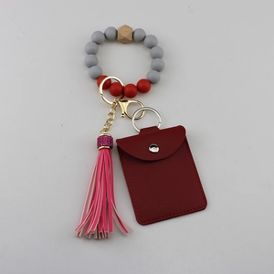 Détail du bracelet en perles silicone avec pompon rose et porte-carte en similicuir