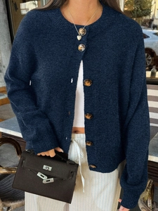 Détail d'un cardigan en maille bleu foncé avec texture gaufrée et gros boutons marron