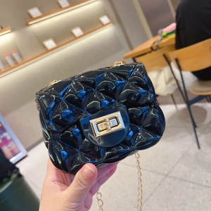 Primer plano de bolso jelly negro brillante con cierre giratorio dorado y asa de cadena