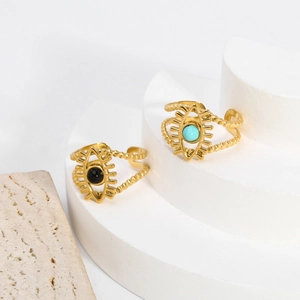 Detail view of gold-plated evil eye rings with black and turquoise stones on a white stand