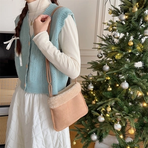 Détail du sac bandoulière en suédine avec bordure en peluche et décor festif