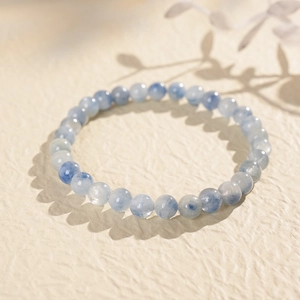 Macro shot of blue beaded crystal bracelet with natural shadow on textured background