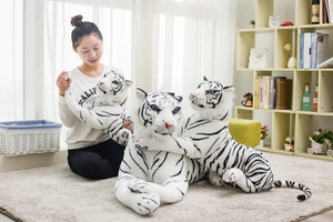 Three sizes of realistic white tiger plush toys shown with a model in a cozy home setting
