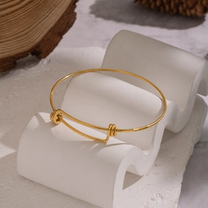 Minimalist adjustable 18K gold plated stainless steel bracelet on elegant stone display
