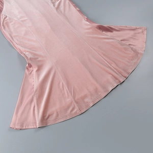 Detailed view of pink velvet dress fabric featuring soft texture and pleated hemline