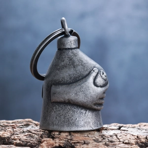 Macro shot of retro silver metal bell pendant with unique double skull hand design
