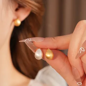 Minimalist matte teardrop earrings in gold and silver finish with brushed metal texture