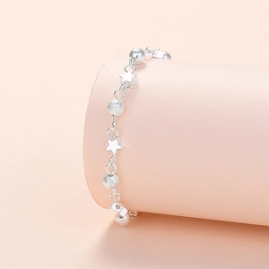 Chic silver beaded planet bracelet with star charms displayed on a pink aesthetic stand